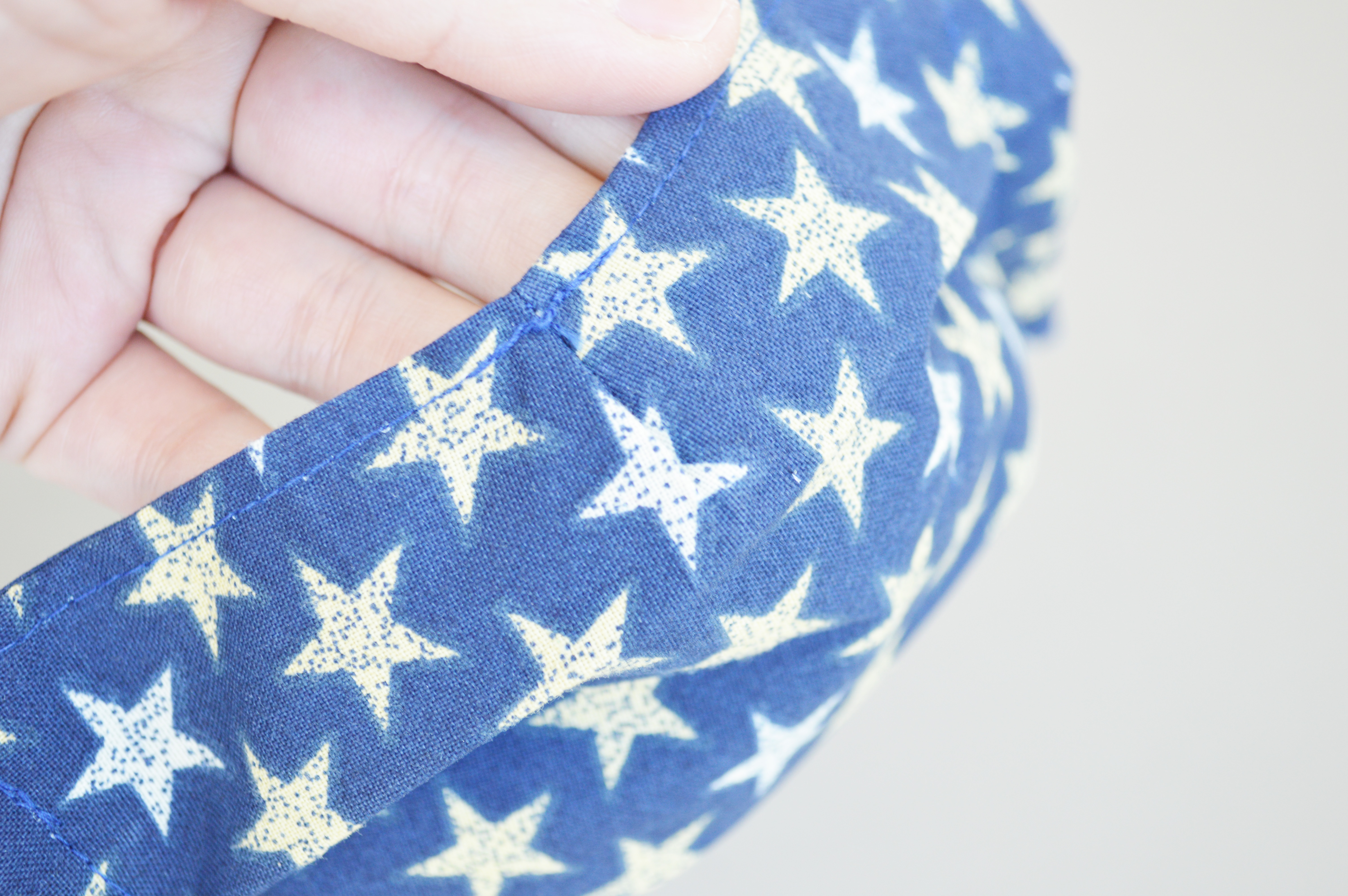 Image of blue cotton-fabric mask with white and gold star pattern, giving a closer look at where the nose bridge would be